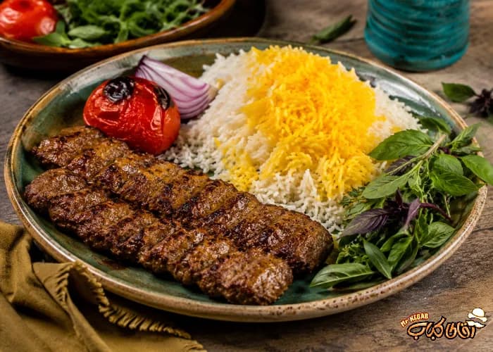 غذای سنتی گیلانی شامل کباب، برنج زعفرانی، گوجه کبابی و سبزی تازه.
